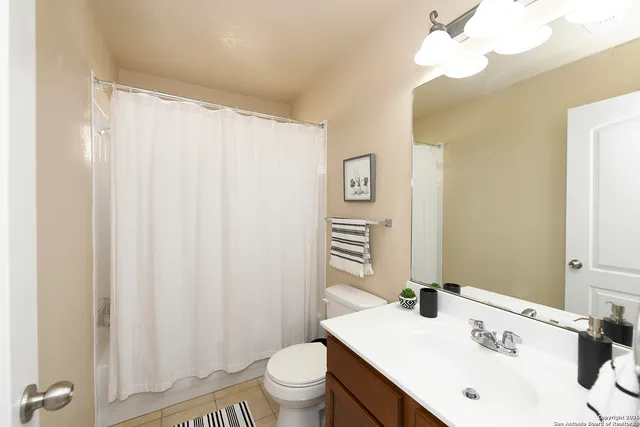 a bathroom with a sink a toilet and a mirror