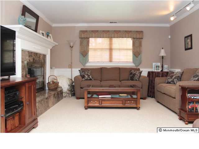 583 Robin Hood Road Brick, NJ 08724 - Photo 12 of 24 a living room with furniture a fireplace and a flat screen tv