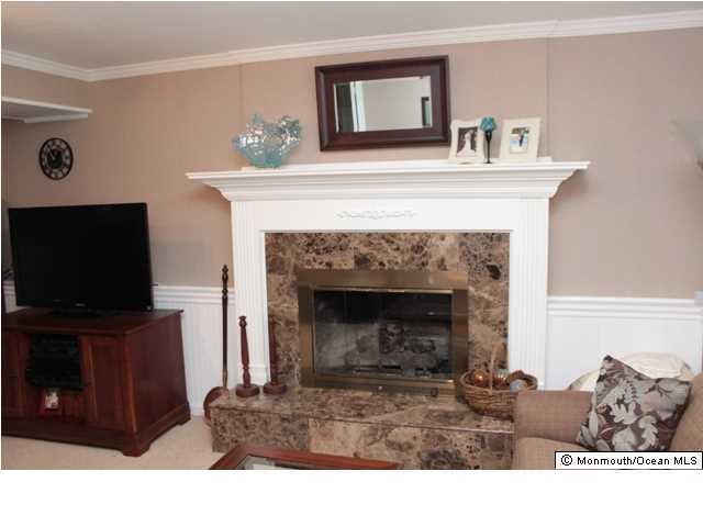 583 Robin Hood Road Brick, NJ 08724 - Photo 13 of 24 a living room with furniture a flat screen tv and a fireplace