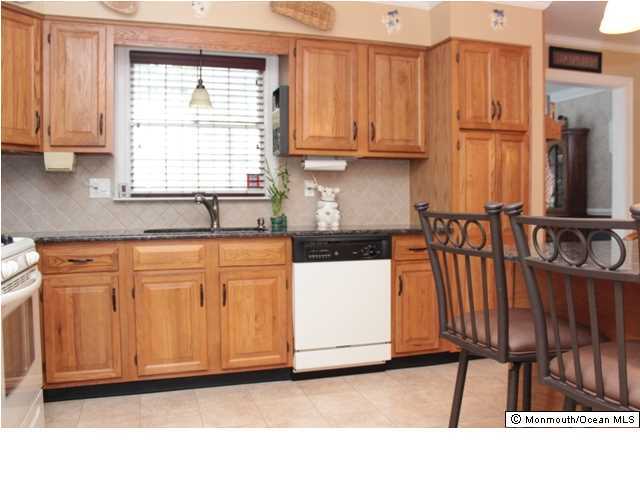 583 Robin Hood Road Brick, NJ 08724 - Photo 5 of 24 a kitchen with wooden cabinets and a sink