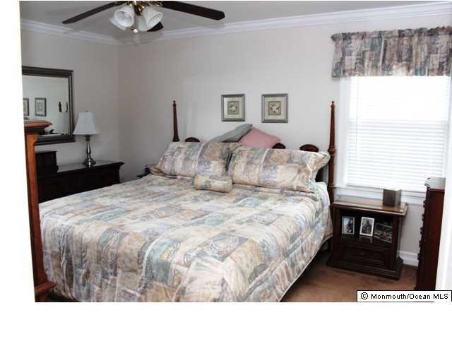 583 Robin Hood Road Brick, NJ 08724 - Photo 9 of 24 a bedroom with a bed and a chandelier