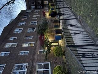 141-35 78th Road, Unit 3M Queens, NY 11367 - Photo 1 of 1 a street view of a brick house with plants and wooden fence