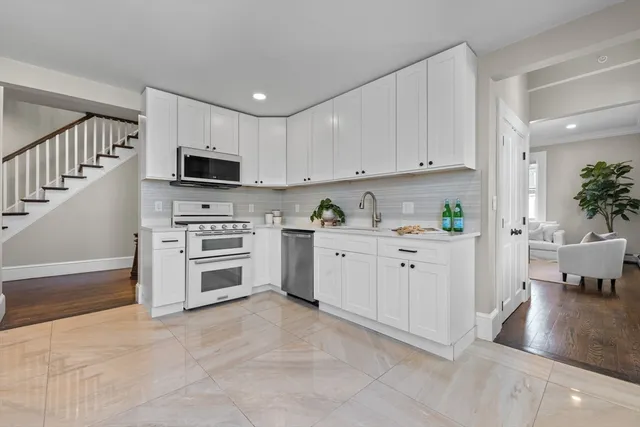 a kitchen with cabinets stainless steel appliances and wooden floor