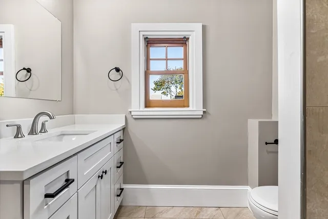 a bathroom with a granite countertop sink a toilet and shower