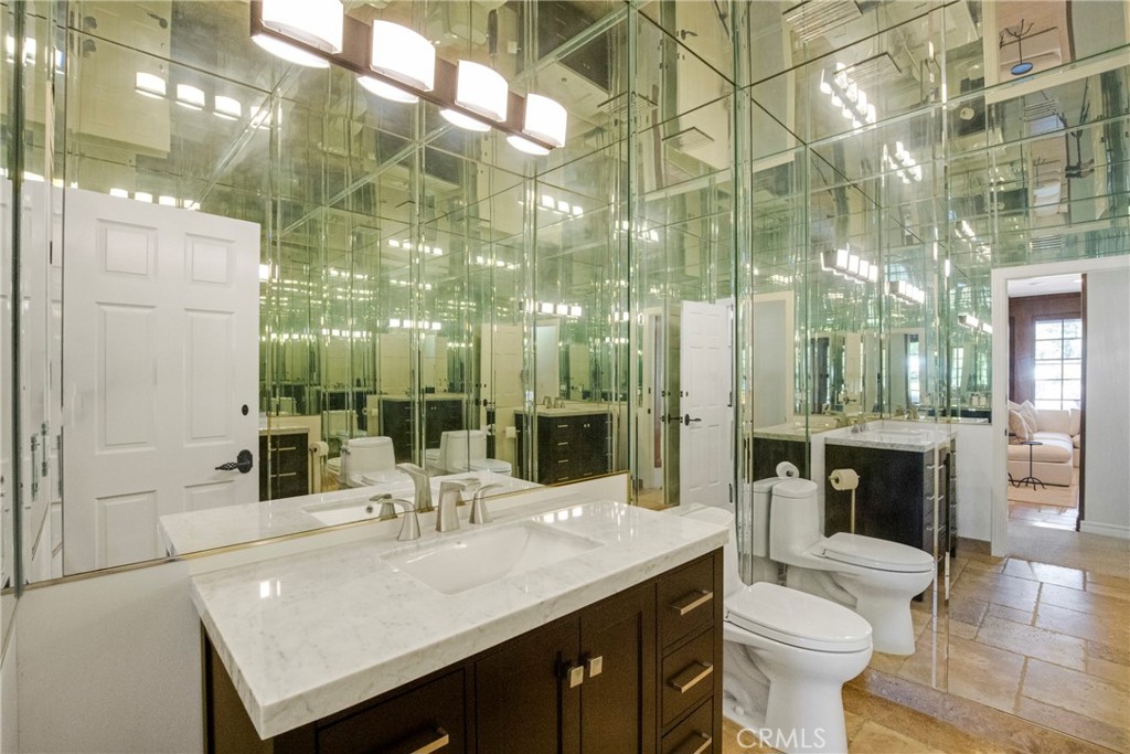 6032 Grey Rock Road Agoura Hills, CA 91301 - Photo 19 of 54 a bathroom with a sink and mirror with toilet