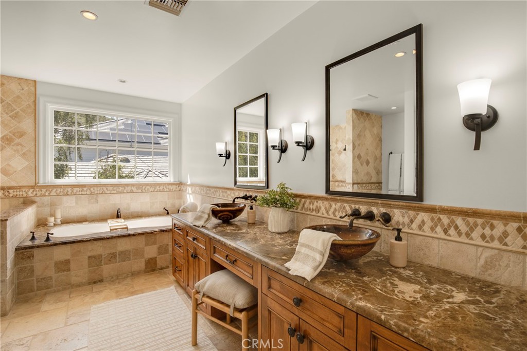 6032 Grey Rock Road Agoura Hills, CA 91301 - Photo 24 of 54 a bathroom with a granite countertop sink and a large mirror