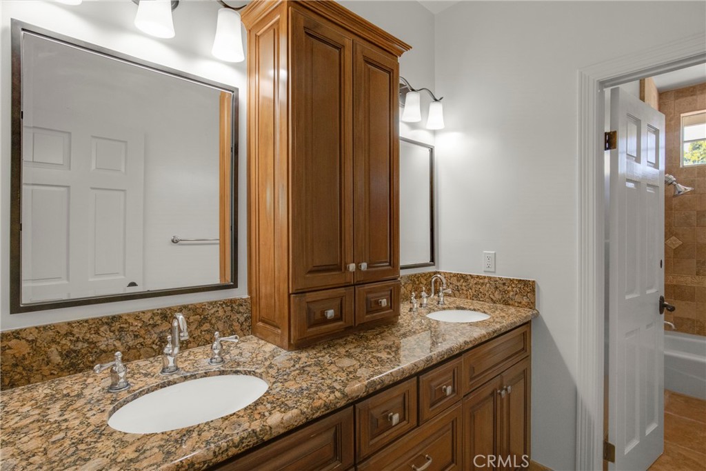 6032 Grey Rock Road Agoura Hills, CA 91301 - Photo 31 of 54 a bathroom with a granite countertop sink and a mirror
