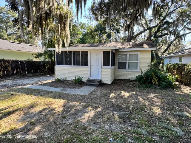 a front view of house with yard and trees in the background