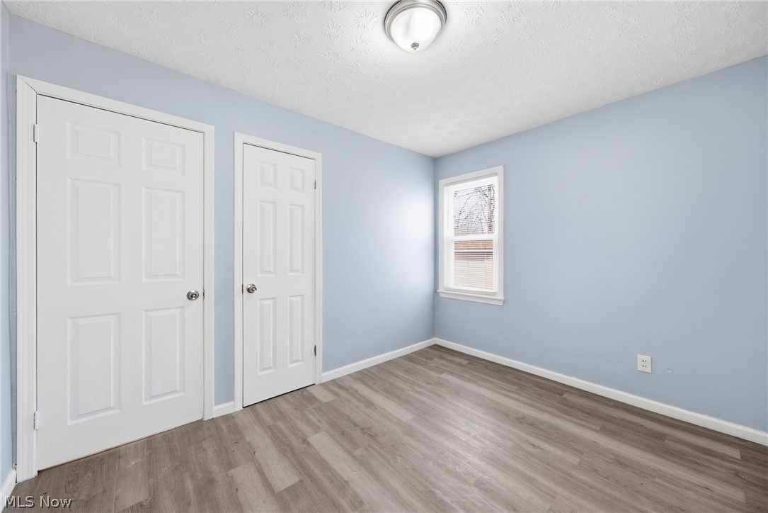 20705 Hansen Road Maple Heights, OH 44137 - Photo 10 of 24 Unfurnished bedroom featuring a textured ceiling, wood finished floors, and a closet