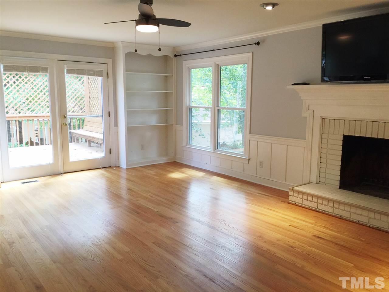 1900 Wilton Circle Raleigh, NC 27615 - Photo 4 of 9 an empty room with windows fireplace and wooden floor
