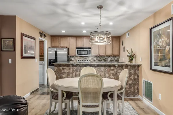a view of a dining room with furniture a chandelier and wooden floor