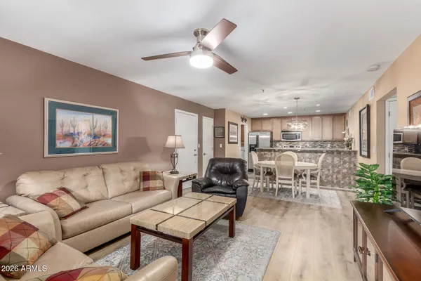 a living room with furniture kitchen view and a chandelier