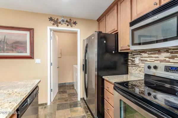 a kitchen with stainless steel appliances granite countertop a refrigerator and a stove top oven