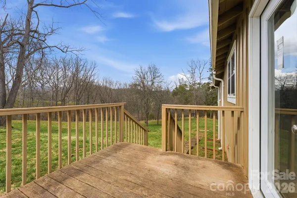 a view of a balcony with wooden floor and fence