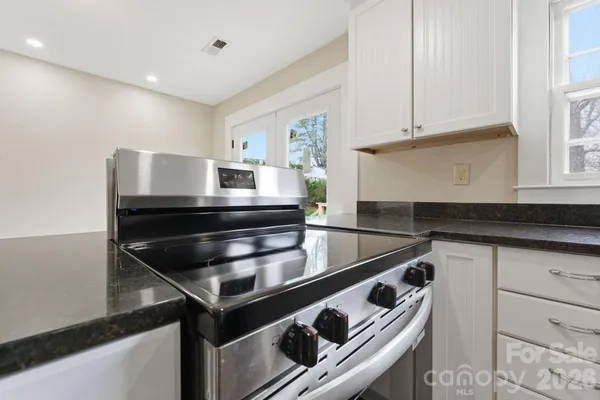 a kitchen with granite countertop a stove and a sink