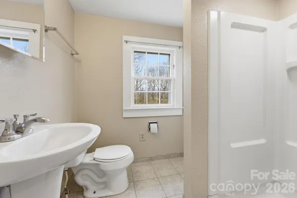 a bathroom with a toilet a sink and a window