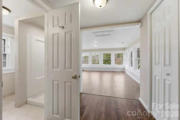 a view of empty room with wooden floor and fan