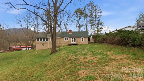 a view of a house with backyard and sitting area