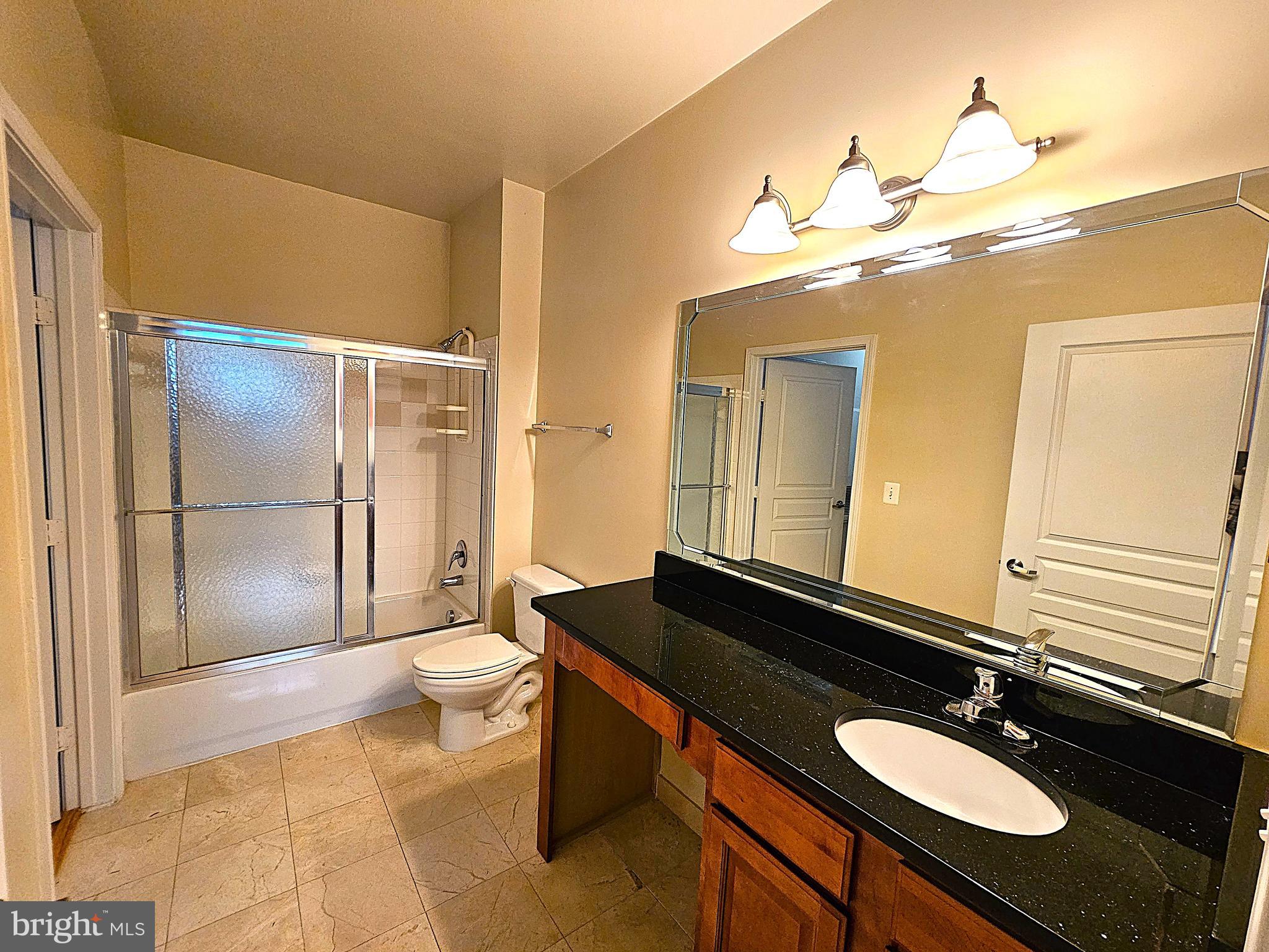 12000 Market Street, Unit 283 Reston, VA 20190 - Photo 23 of 36 a bathroom with a sink a toilet a mirror and shower