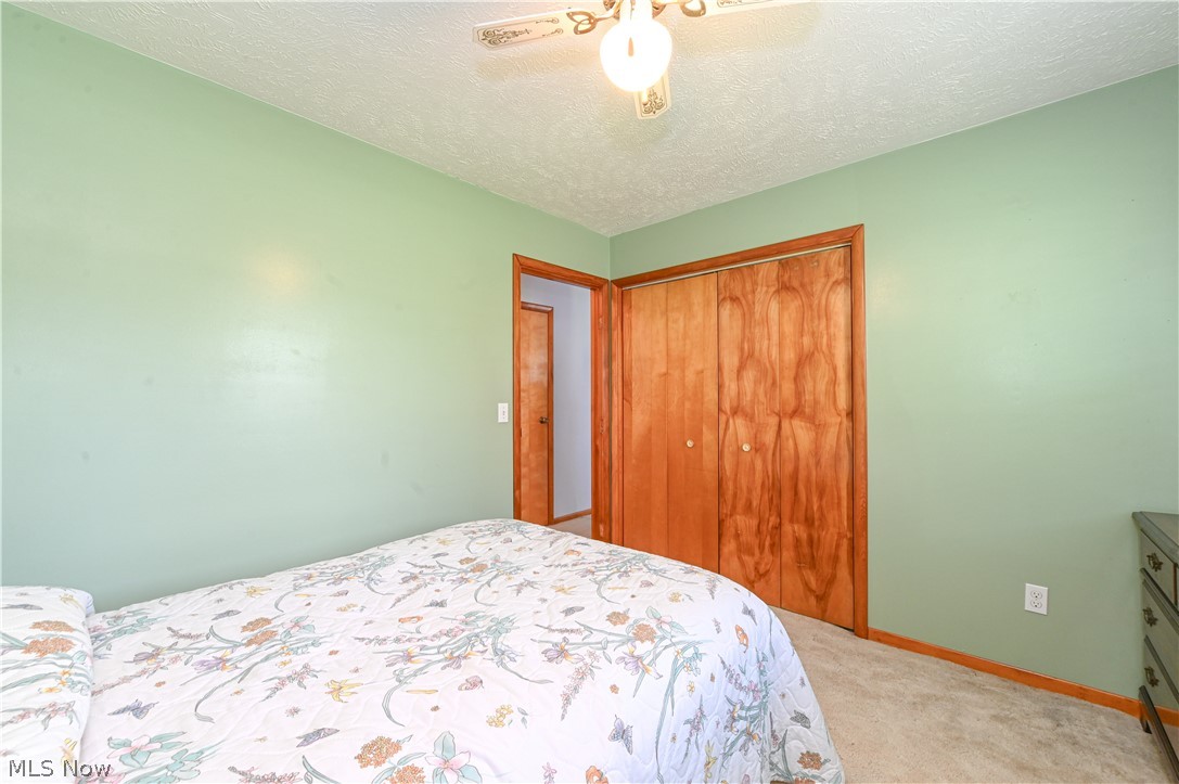 13425 Chardon-Windsor Road Chardon, OH 44024 - Photo 23 of 50 Bedroom featuring a closet, ceiling fan, carpet, and a textured ceiling