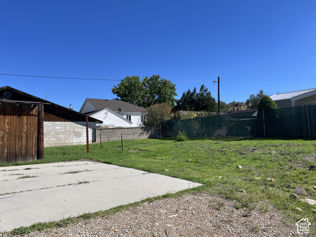 265 Roosevelt Street Helper, UT 84526 - Photo 4 of 27 Expansive lot featuring a concrete pad, gravel area, and chain-link fencing