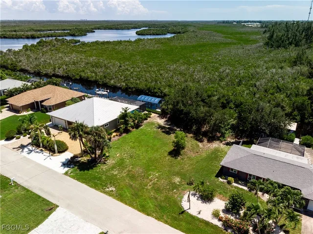 an aerial view of residential houses with outdoor space and trees