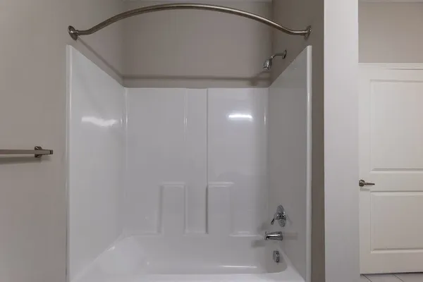 an empty room with wooden floor ceiling fan and windows