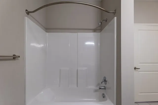 an empty room with wooden floor ceiling fan and windows