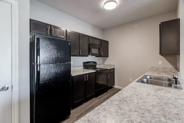 a kitchen with stainless steel appliances granite countertop a stove refrigerator and microwave