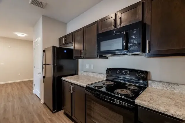 a kitchen with sink refrigerator and cabinets