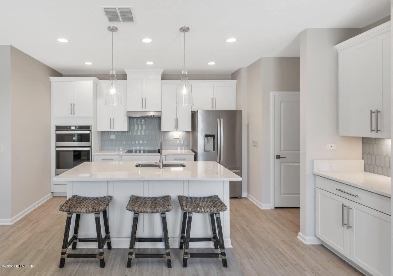 510 Modesto Drive St. Augustine, FL 32086 - Photo 5 of 38 a kitchen with kitchen island white cabinets and stainless steel appliances