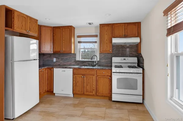 a kitchen with stainless steel appliances granite countertop a refrigerator sink and stove