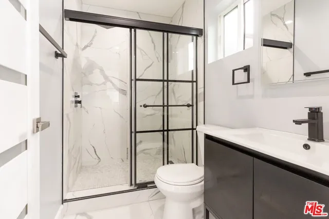 a bathroom with a sink a toilet and shower