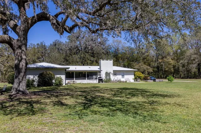 a view of a house with backyard tub and chairs
