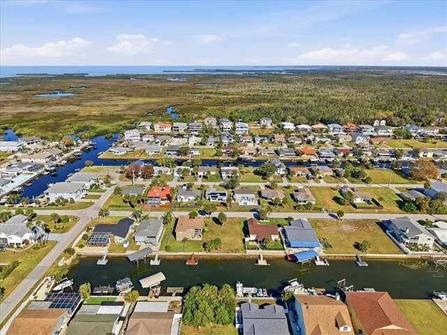 an aerial view of ocean and residential houses with outdoor space