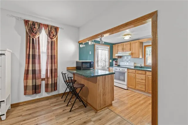 a kitchen with granite countertop wooden floors and white stainless steel appliances