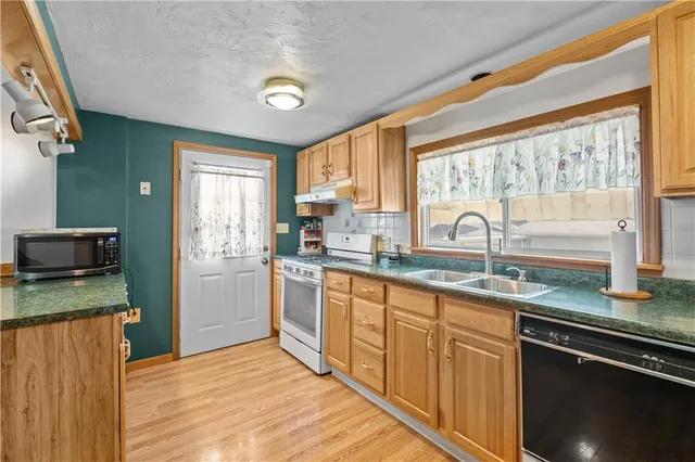 a kitchen with granite countertop a sink and a refrigerator