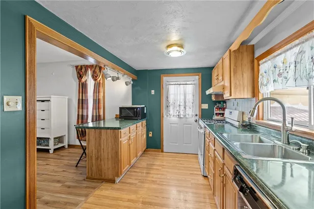 a kitchen with stainless steel appliances granite countertop sink stove top oven and refrigerator