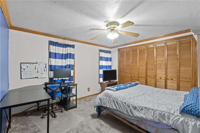 a bedroom with a bed a desk and chair with the potted plant