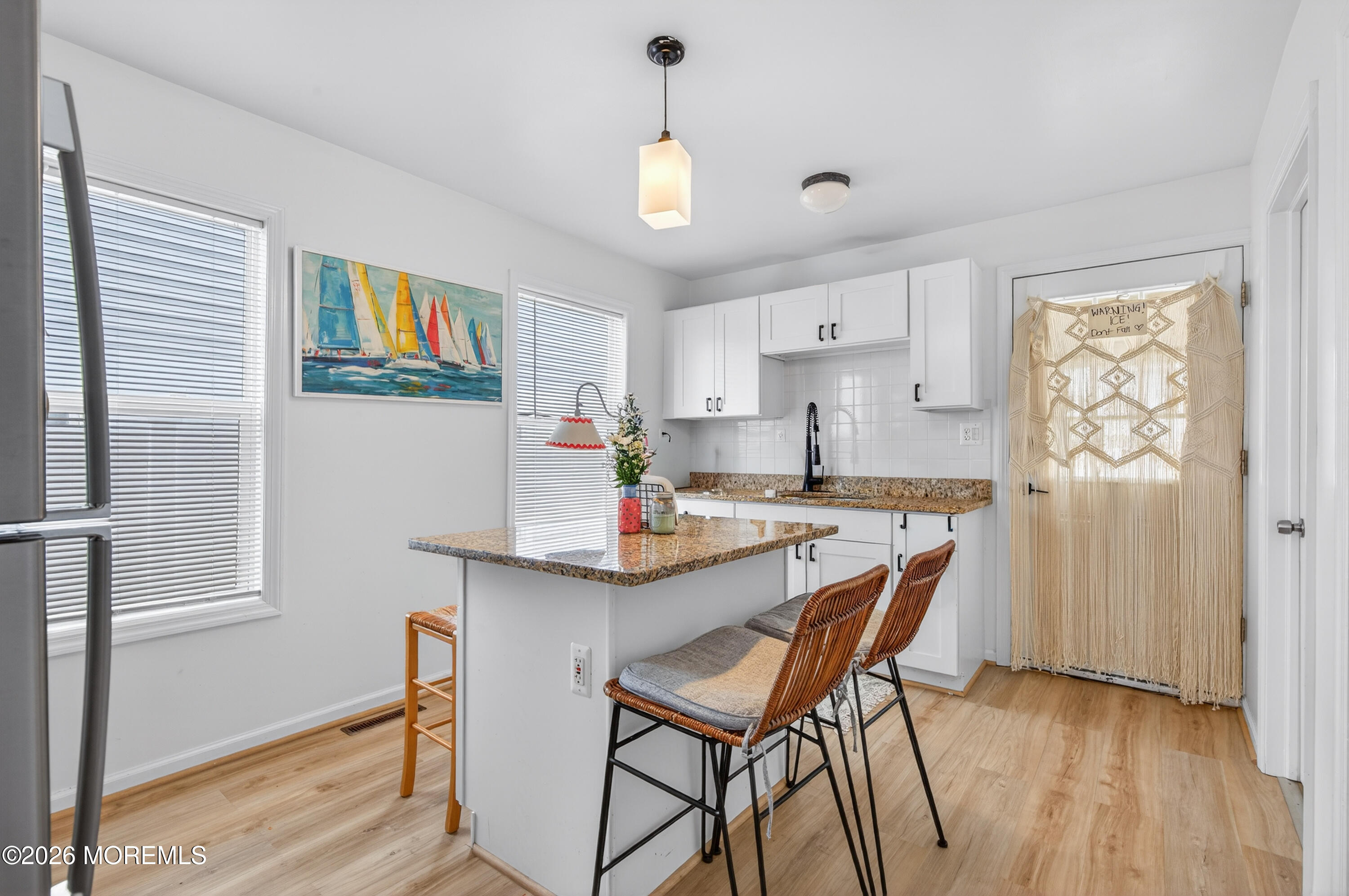 191 3rd Avenue, Unit 1 Manasquan, NJ 08736 - Photo 5 of 8 a kitchen with stainless steel appliances a table and chairs in it