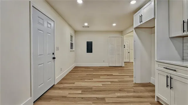 a view of a hallway with wooden floor and staircase