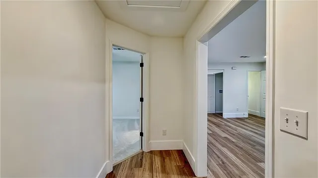 a view of a room with wooden floor and a bathroom