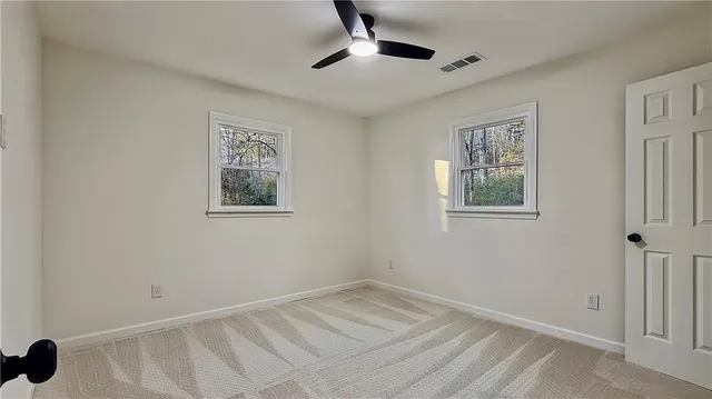 a view of room with a ceiling fan and a window