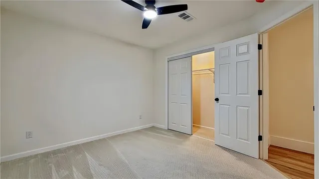a view of a livingroom with a ceiling fan & entryway