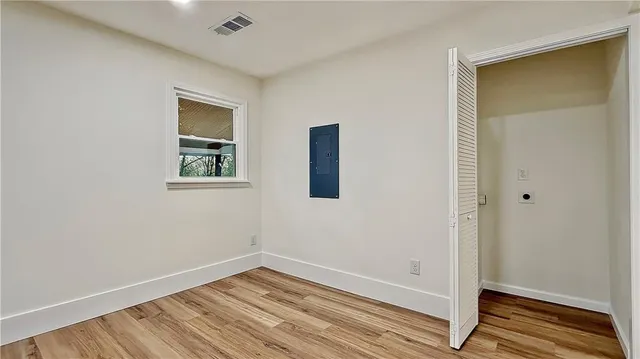 an empty room with a closet and wooden floor