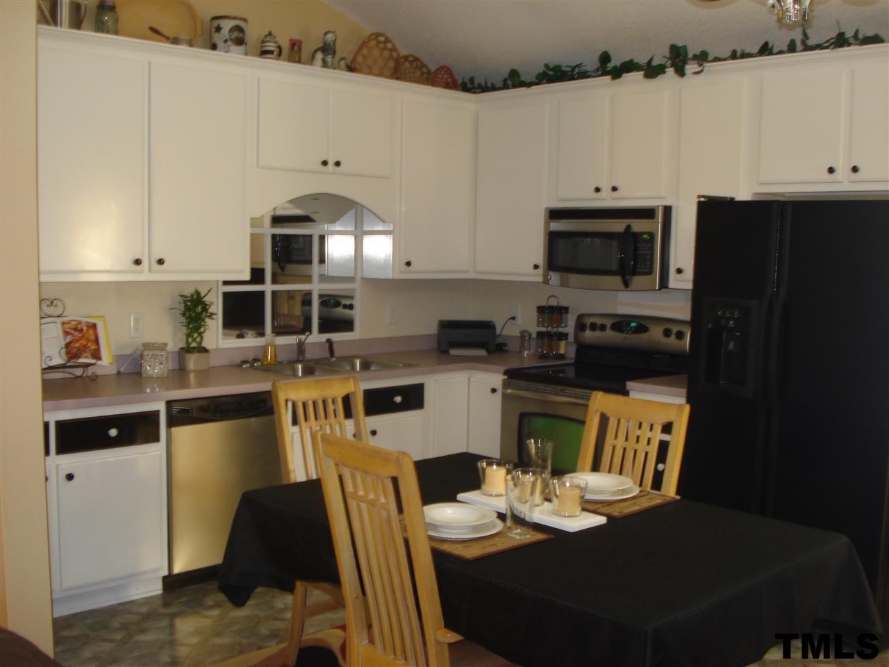 3755 Old Stage Road North Angier, NC 27501 - Photo 2 of 15 a kitchen with stainless steel appliances kitchen island granite countertop a refrigerator a stove a sink dishwasher and white cabinets with wooden floor