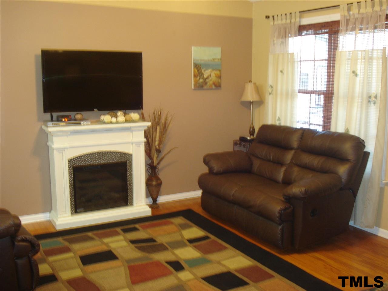 3755 Old Stage Road North Angier, NC 27501 - Photo 6 of 15 a living room with furniture a flat screen tv and a fireplace