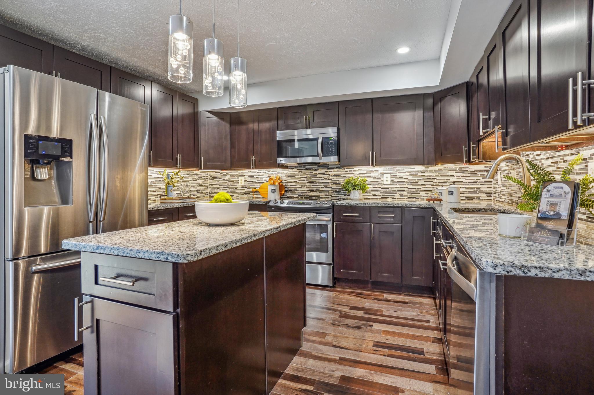 6377 Generals Court Centreville, VA 20121 - Photo 12 of 32 a kitchen with stainless steel appliances granite countertop a sink stove and refrigerator
