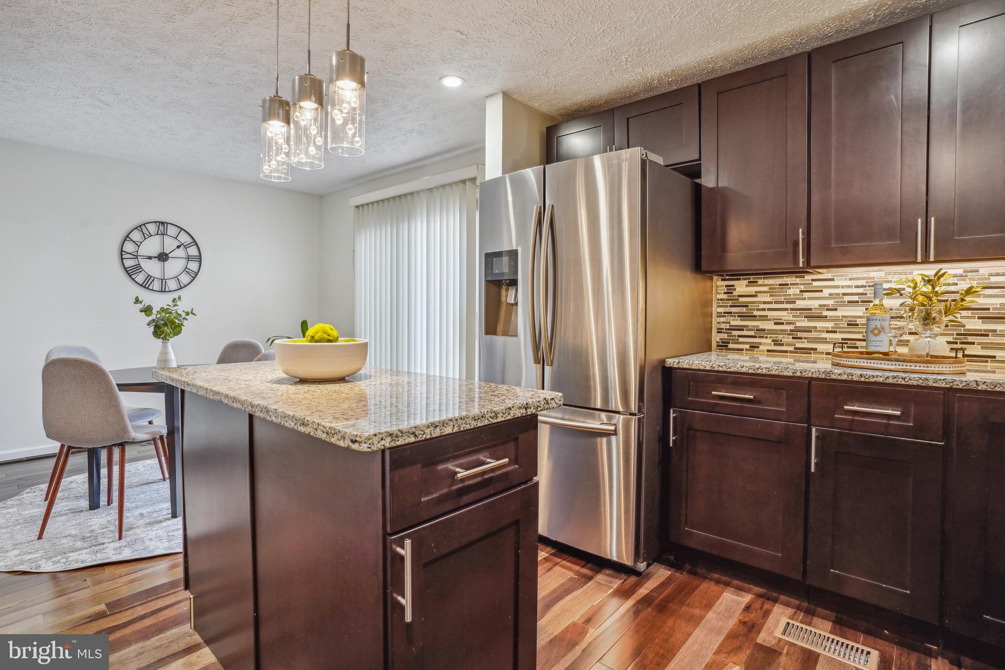 6377 Generals Court Centreville, VA 20121 - Photo 15 of 32 a kitchen with stainless steel appliances granite countertop a refrigerator a stove and a wooden cabinets