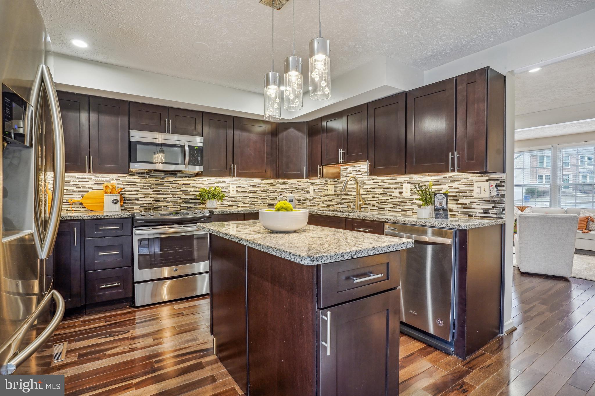 6377 Generals Court Centreville, VA 20121 - Photo 10 of 32 a kitchen with stainless steel appliances granite countertop wooden cabinets and a stove top oven